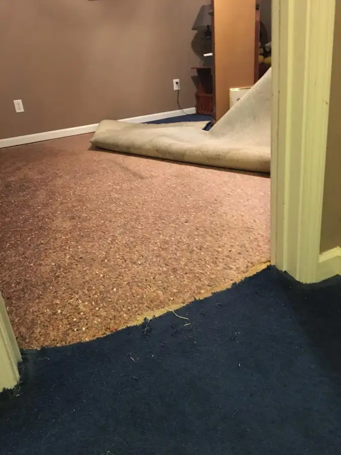 Carpet pad removal revealing water damage during Water Mitigation Services in Carlyss